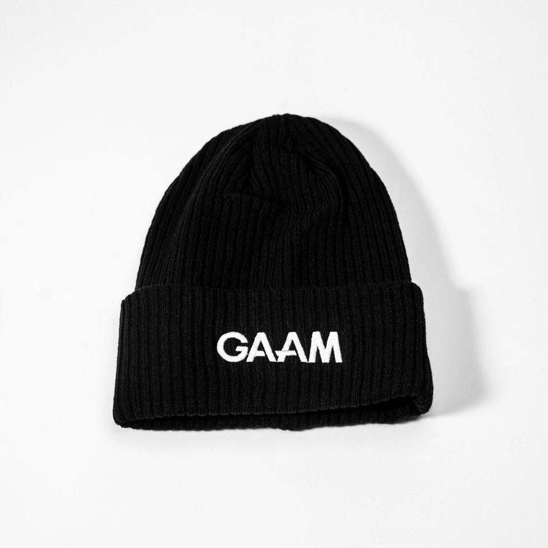 GAAM Beanie Black, en svart ribbstickad mössa med uppvikt kant och tydlig vit logotyp framtill.