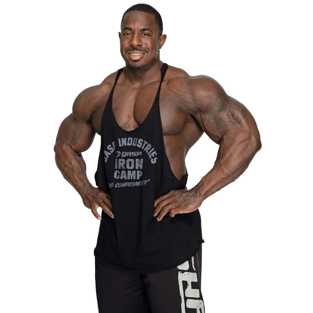GASP Stringer Tank Black, ett svart träningslinne i bomull med klassisk stringermodell och brösttryck, buret av en man., bild 5 av 6