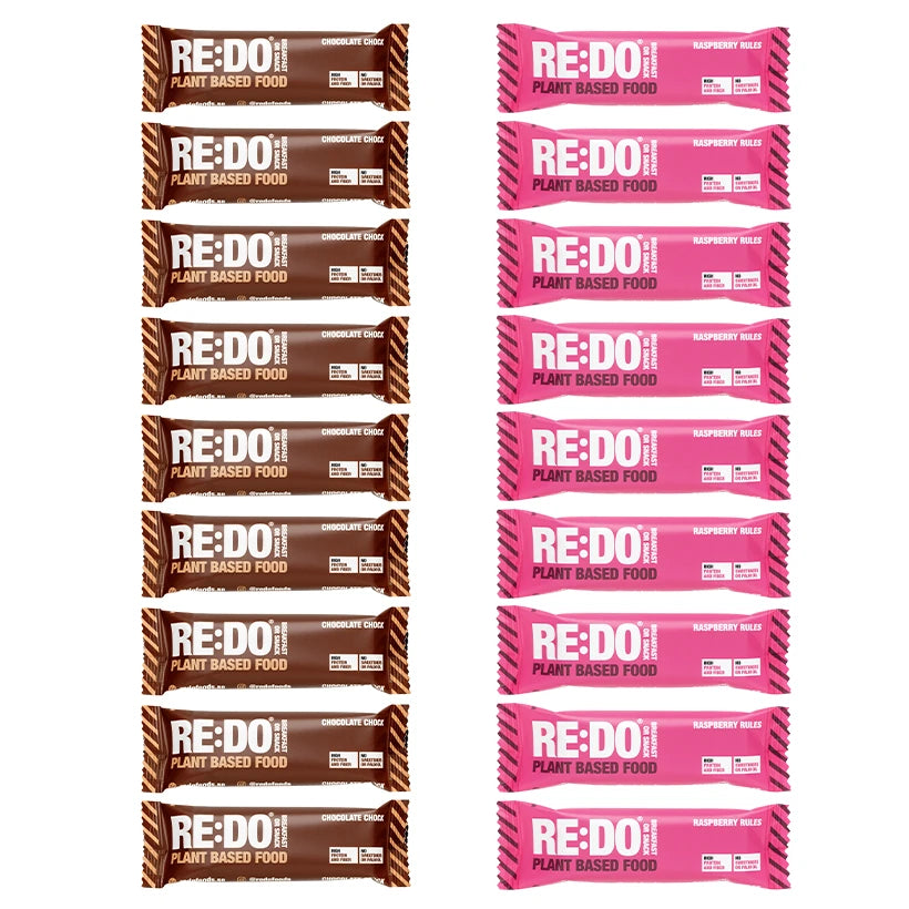 18 x REDO Bar 60 g Mixlåda med plantbaserade bars i bruna och rosa förpackningar för smakerna choklad och hallon.