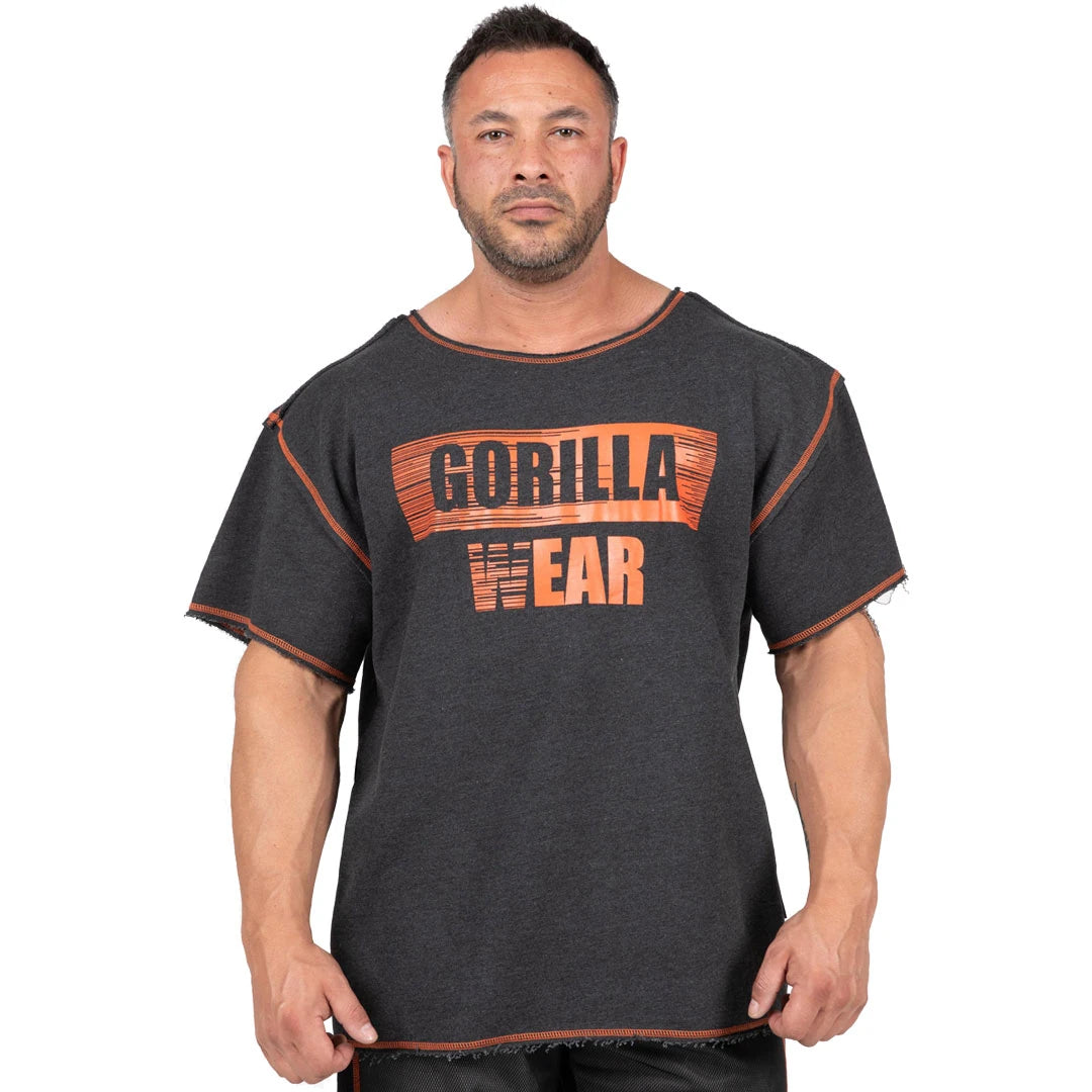 Mörkgrå Gorilla Wear Wallace Workout Top Grey/Orange, en oversized träningst-shirt med orange logga och råa kanter.