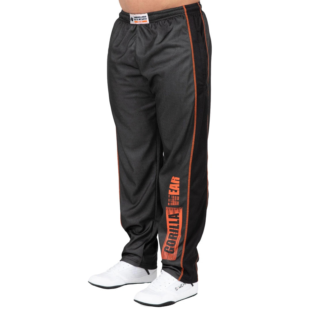 Gorilla Wear Wallace Mesh Pants Grey/Orange är lössittande träningsbyxor i grå mesh med orange sömmar och logotyp., bild 3 av 4