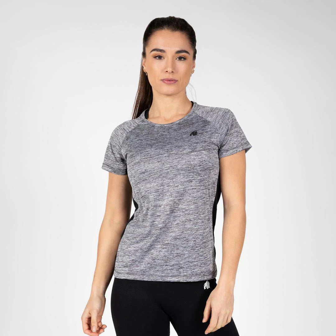 Gorilla Wear Monetta Performance T-Shirt Grey Melange/Black, en gråmelerad träningst-shirt buren av en kvinna., bild 1 av 5