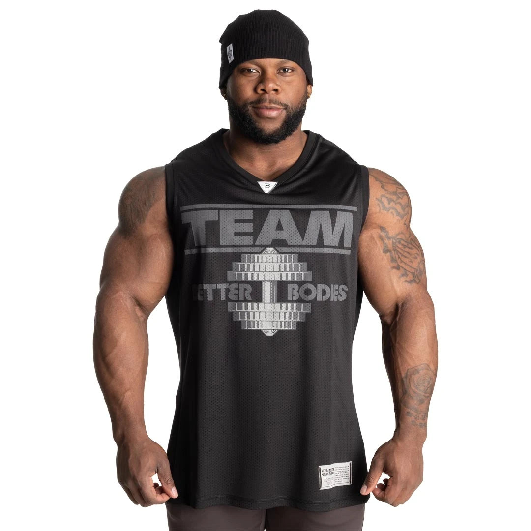 Better Bodies Iron Mesh Tank Black, ett svart träningslinne i mesh med stort brösttryck buret av en man., bild 2 av 2