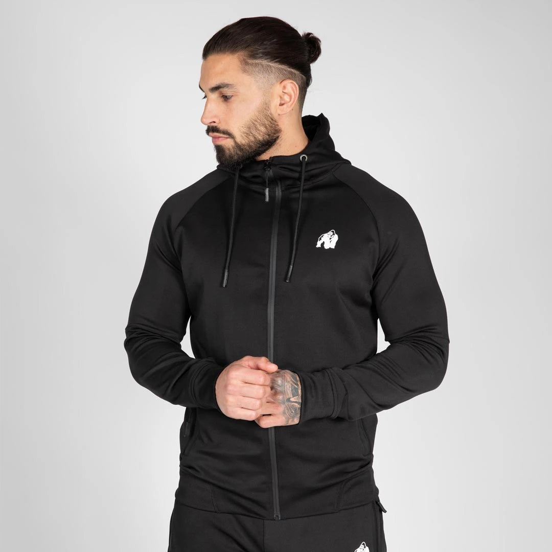 Gorilla Wear Sullivan Track Jacket Black, en svart sportig träningsjacka med dragkedja, huva och vit logga på bröstet., bild 3 av 7