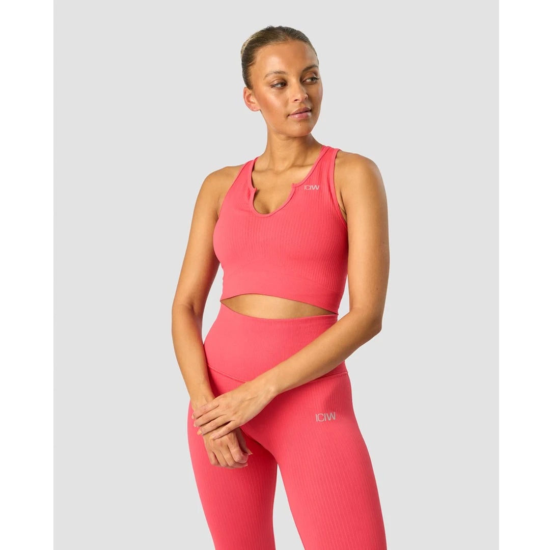 Modell i ICANIWILL Ribbed Define Seamless Tank Top Coral Red, ett sömlöst och ribbat träningslinne., bild 2 av 2