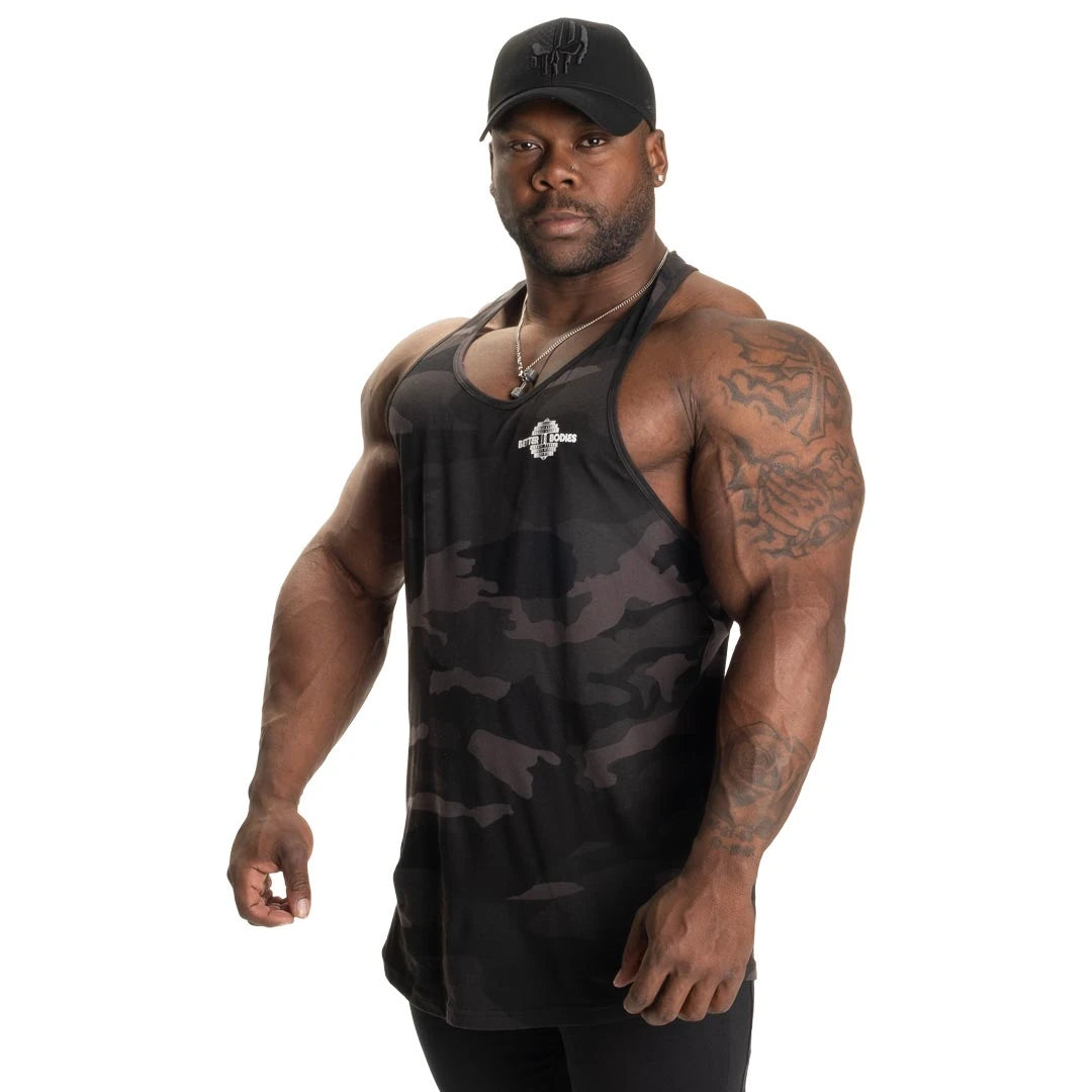 Better Bodies Essential T-back V2 Dark Camo träningslinne i mörkgrått kamouflage med T-rygg på en manlig modell., bild 5 av 6