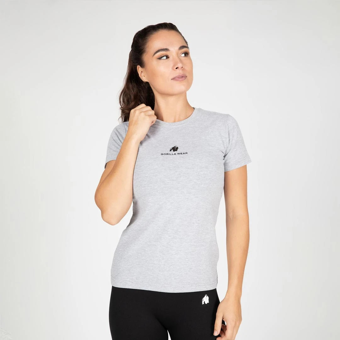 Kvinna bär Gorilla Wear Estero T-Shirt grey melange, en ljusgrå figursydd t-shirt i bomull med svart logga på bröstet., bild 2 av 6
