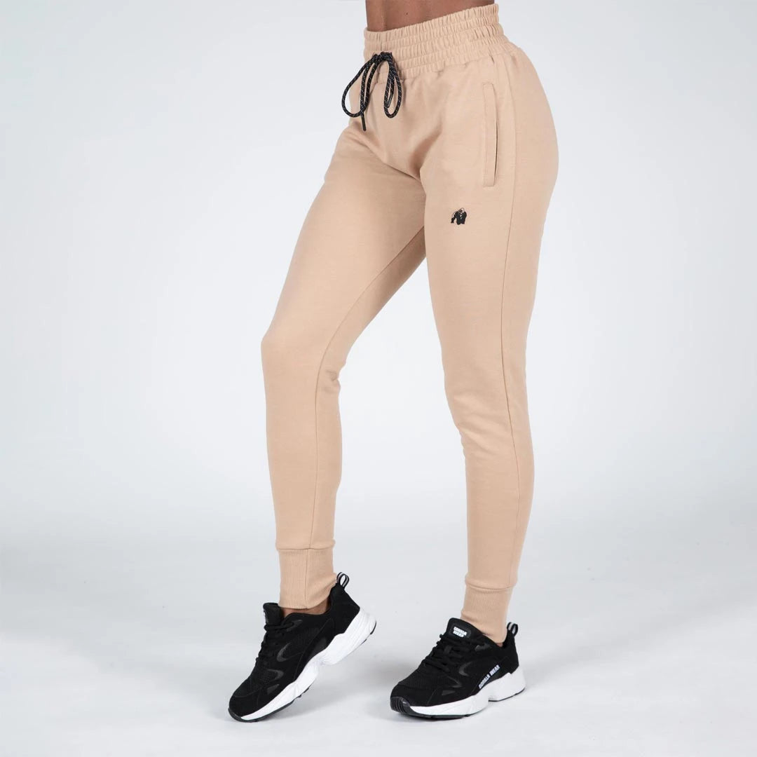 Gorilla Wear Marion Sweatpants beige, mjuka träningsbyxor i bomullsblandning med svart dragsnöre och mudd i benslut.