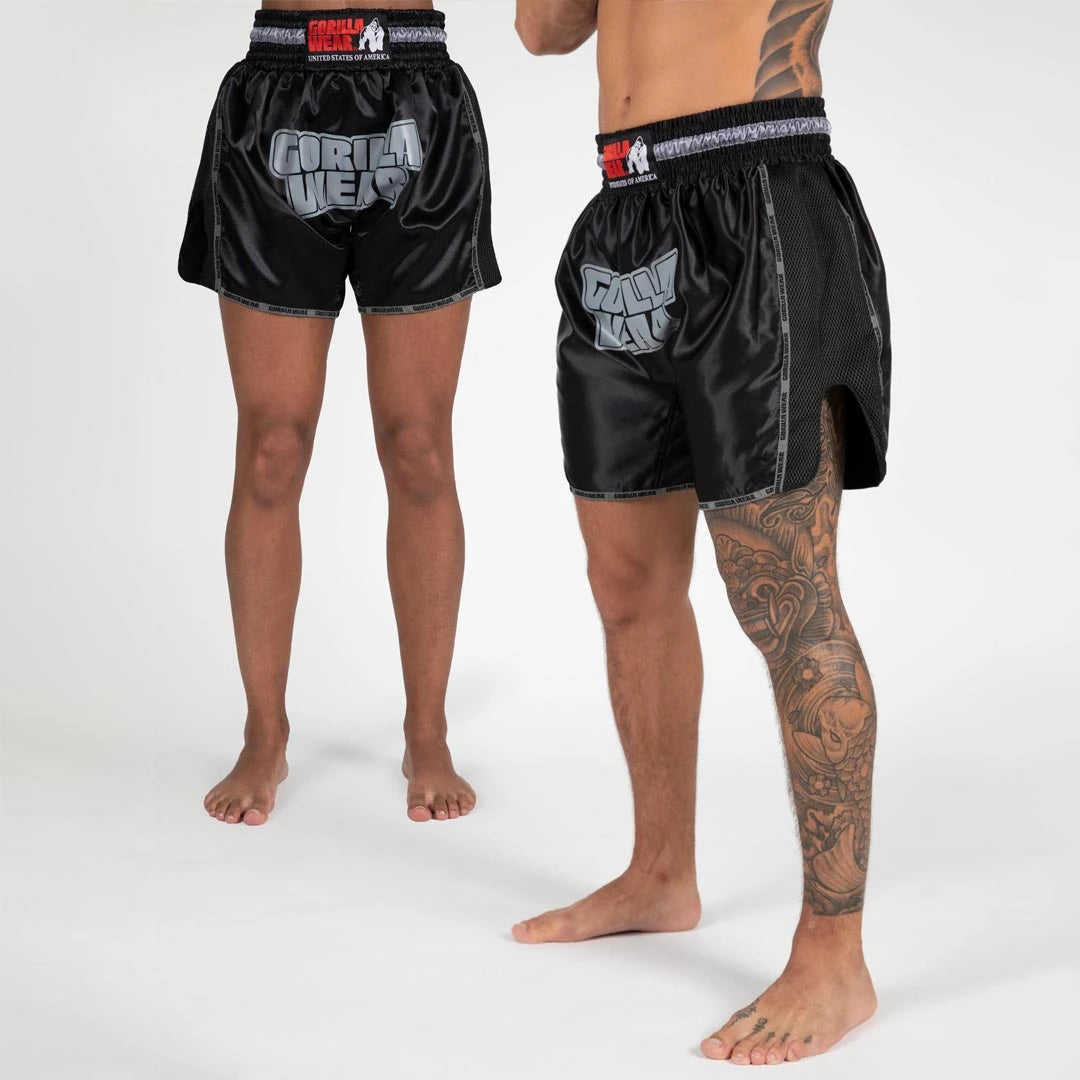 Gorilla Wear Piru Muay Thai Shorts black i glansigt material med stor grå logotyp, sidoslitsar och elastisk midja., bild 1 av 7