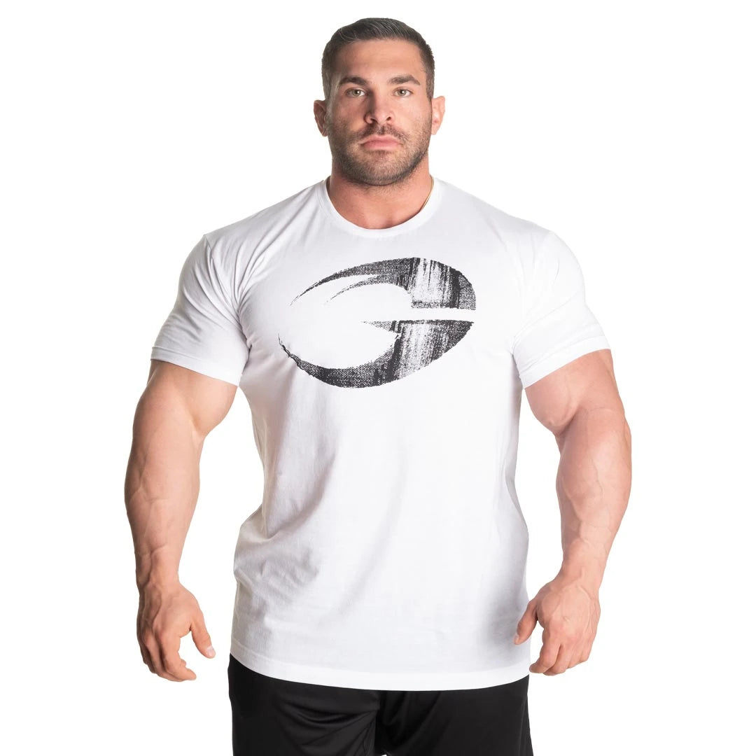 GASP Cadet Tee White, en vit tränings-t-shirt i bomullsblandning med stor svart logga, buren av en muskulös man., bild 4 av 8