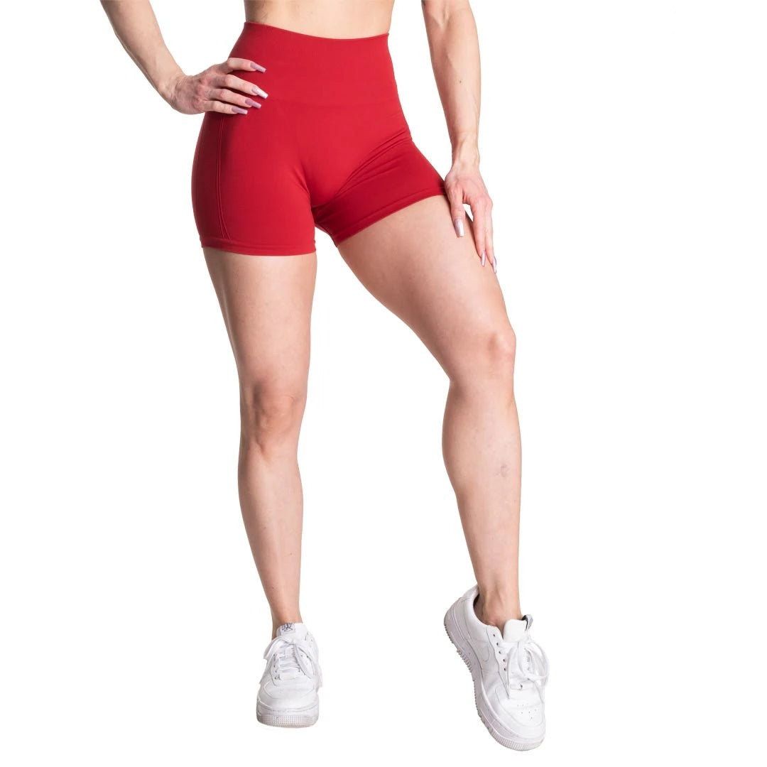Better Bodies Scrunch Shorts Chili Red, röda träningsshorts med hög midja som bärs av en modell.