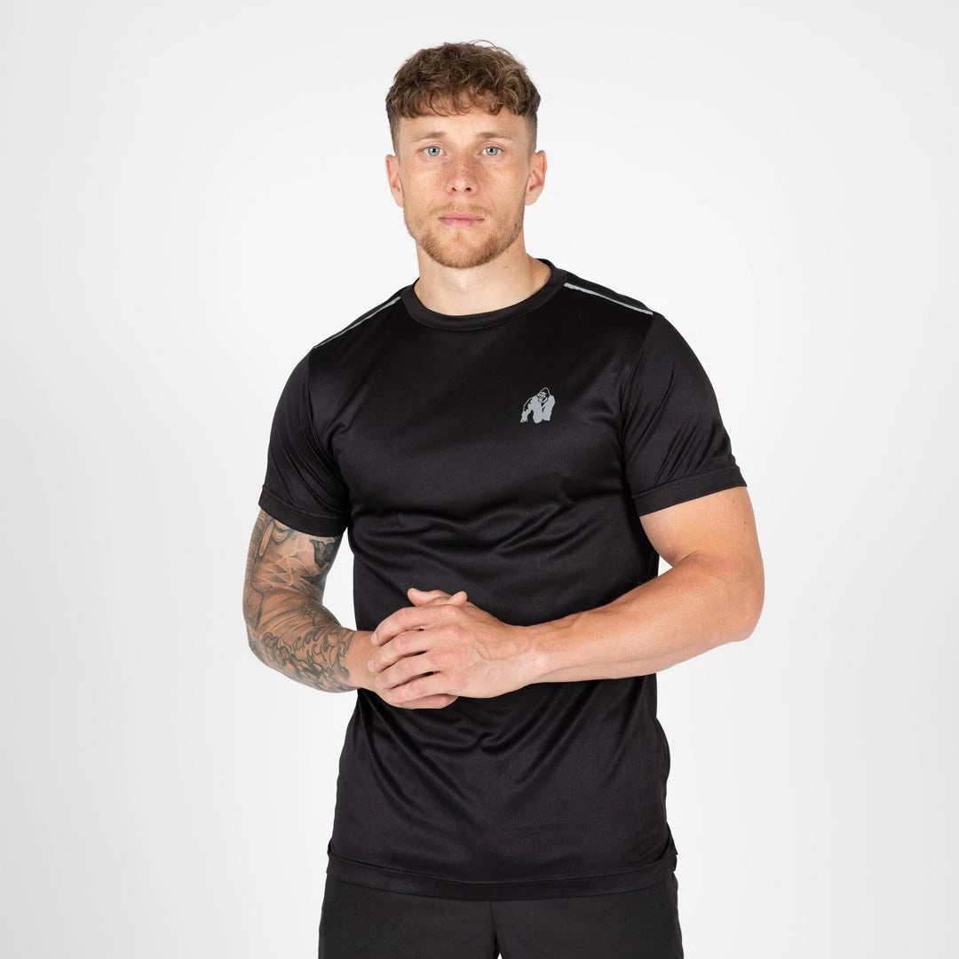 Gorilla Wear Washington T-Shirt Black buren av en modell, en svart tränings-t-shirt i polyester med reflekterande logotyp.