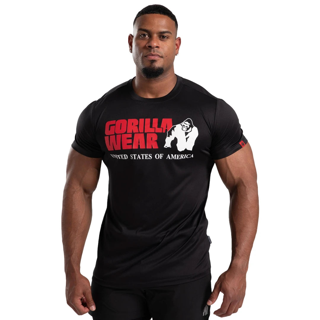 Man bär Gorilla Wear Classic Training T-Shirt Black, en svart tränings-t-shirt med stor röd logotyp på bröstet., bild 4 av 7