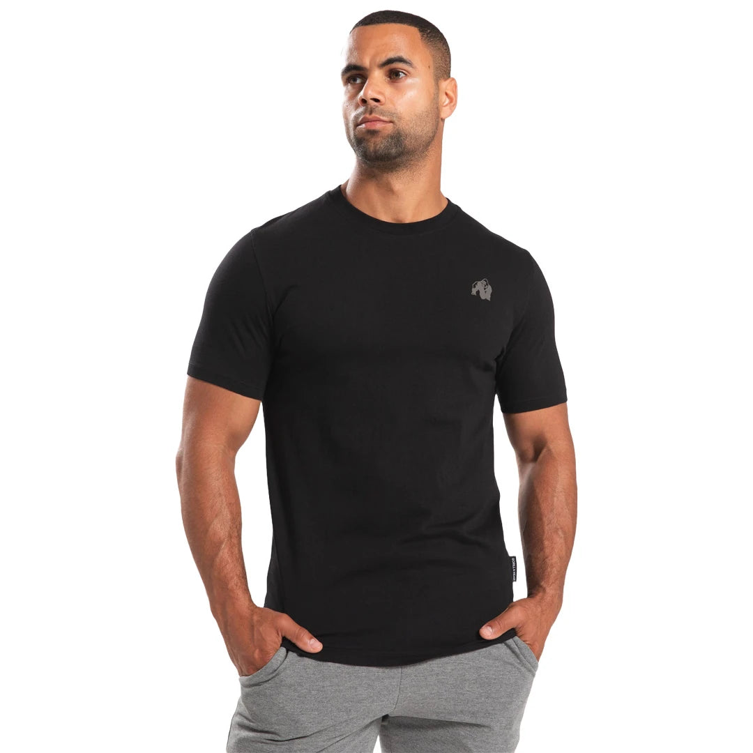 Man klädd i Gorilla Wear Oregon T-Shirt Black, en svart träningströja i bomull med normal passform., bild 5 av 8