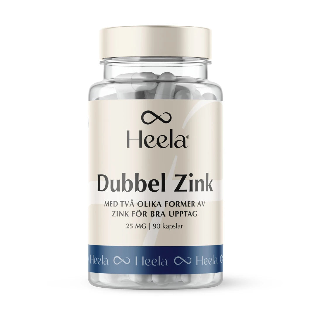 Heela Dubbel Zink 60 caps i en transparent burk med vita kapslar, beigefärgad etikett och blå bottenrand., bild 1 av 1
