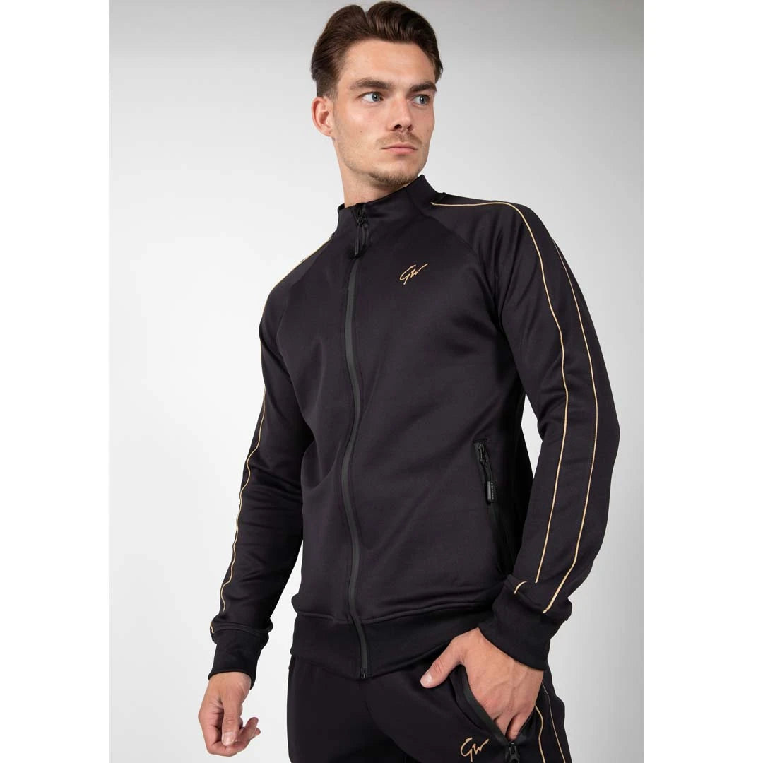 Gorilla Wear Wenden Track Jacket Black/Gold, en svart träningsjacka med guldränder och logotyp buren av en modell., bild 3 av 8