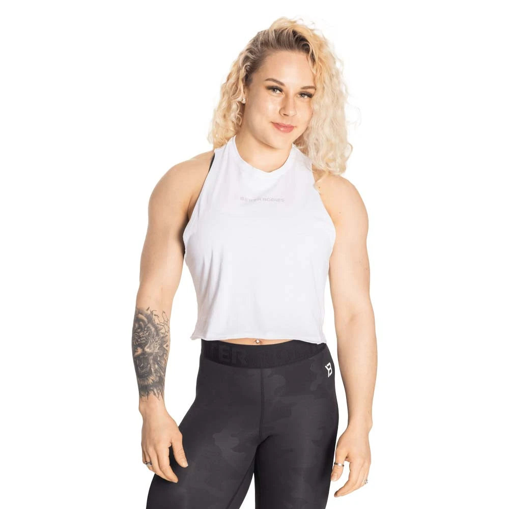 Kvinna klädd i Better Bodies Fluid Loose Racerback White, ett vitt och croppat träningslinne med lös passform., bild 2 av 2