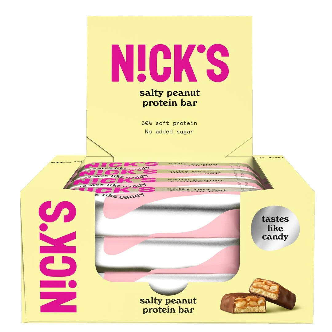 12 x NICKS Soft bar 50 g Salty Peanut SUPER DEAL i en ljusgul låda fylld med proteinbars i rosa och vita omslag., bild 1 av 1
