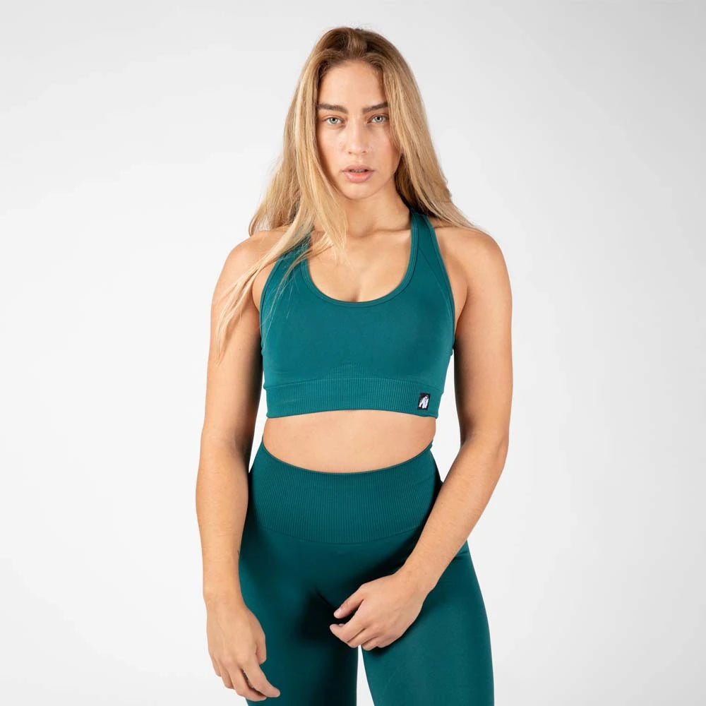Gorilla Wear Yava Seamless Sport Bra Green, en grön sömlös sport-bh med ribbad linning buren av en modell., bild 3 av 3