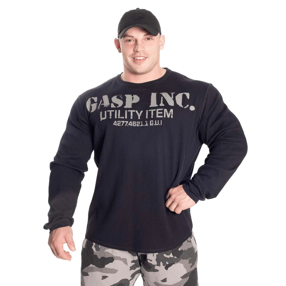 GASP Thermal Gym Sweater Asphalt, en mörkgrå träningströja med stort brösttryck buren av en manlig modell.